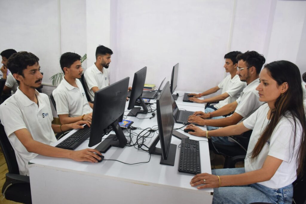 A team from Gashwa Institute of Technical Education collaborates at a desk, focused on their computers in a modern office setting.