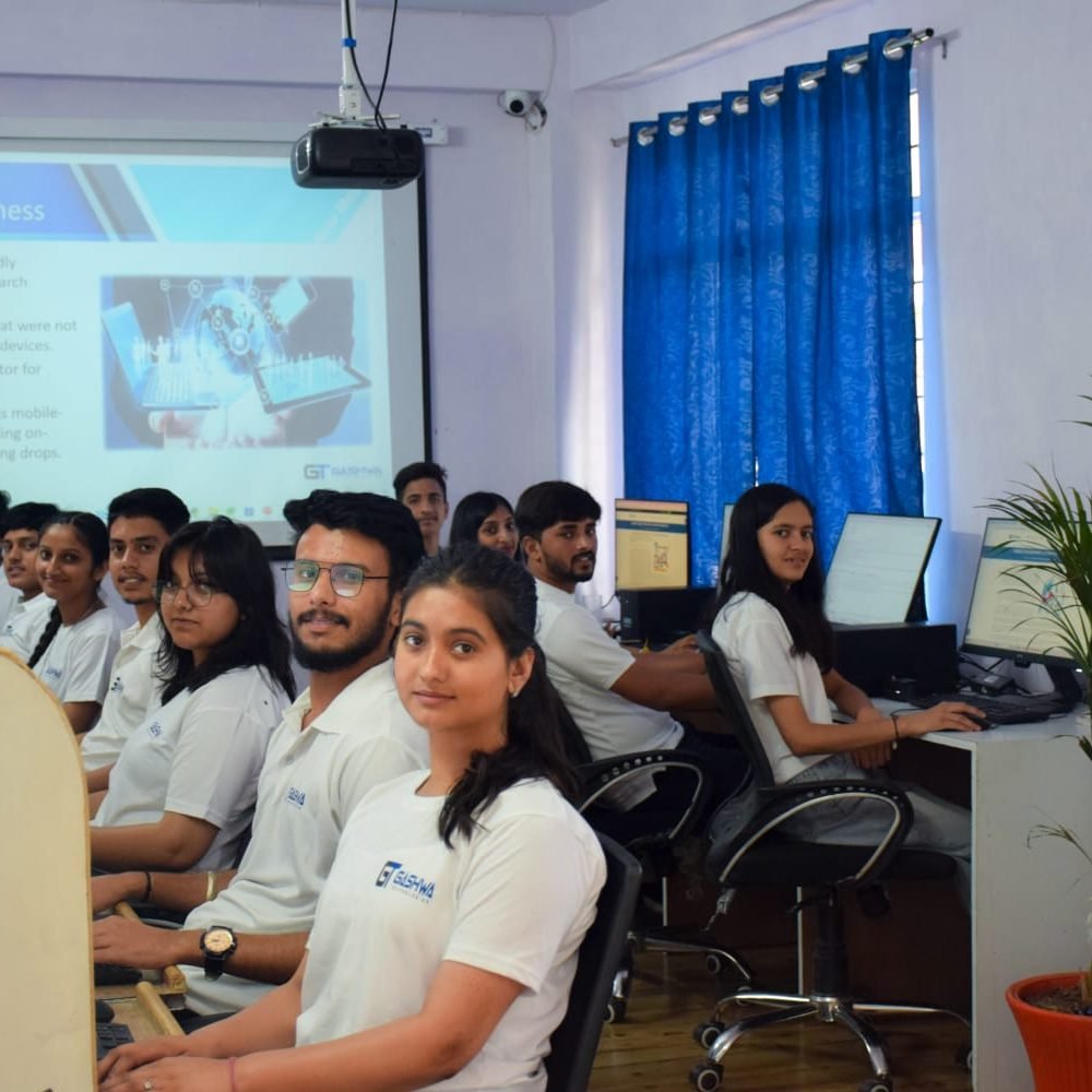 Students in white shirts focused on their computers during a training program at Gashwa Technologies Private Limited.