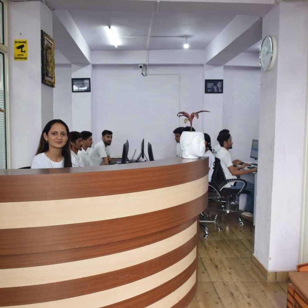 Receptionist at Gashwa Technologies, a woman sitting at the desk in a compact office, ready to assist clients.