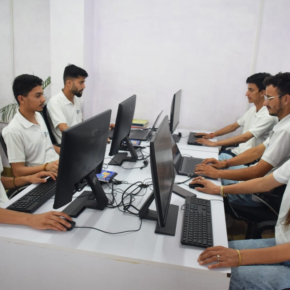 A team from Gashwa Technologies collaborates at a desk, focused on their computers in a modern office setting.