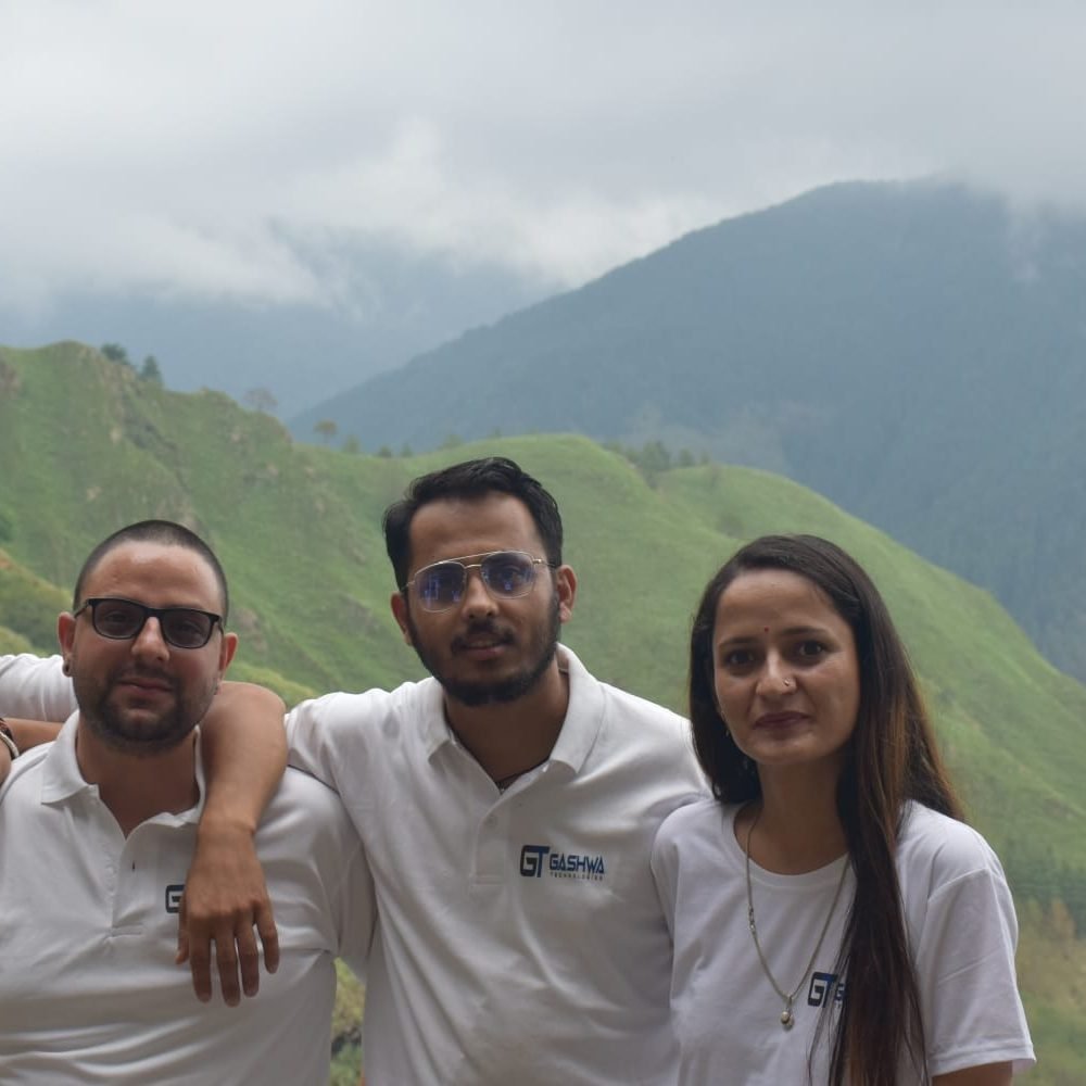 Four individuals in white shirts stand on a mountain, embodying unity and progress at Gashwa Technologies Private Limited.