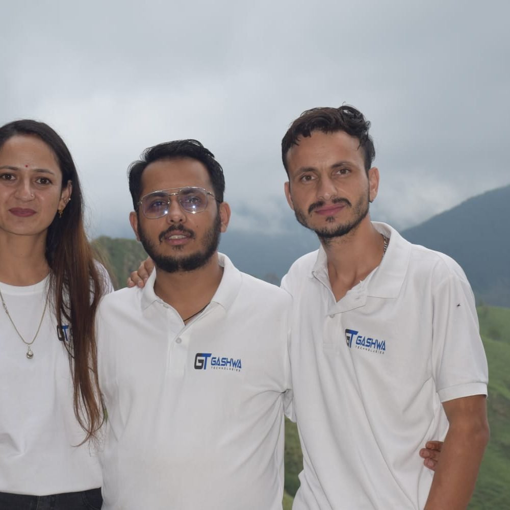 Three people wearing white shirts pose on a mountain, symbolizing collaboration and success at Gashwa Technologies Private Limited.